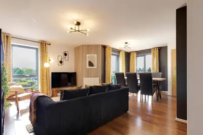 a living room with a couch and a dining room at Pass the Keys Spacious and Modern Flat with own Car Park in Cambridge