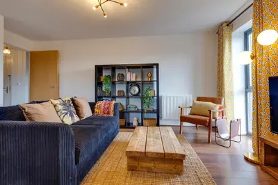 a living room with a blue couch and a wooden coffee table at Pass the Keys Spacious and Modern Flat with own Car Park in Cambridge