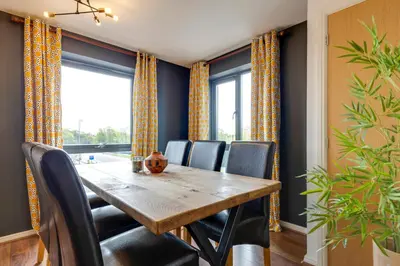 a dining room with a wooden table and chairs at Pass the Keys Spacious and Modern Flat with own Car Park in Cambridge