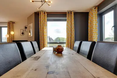 a dining room with a wooden table and chairs at Pass the Keys Spacious and Modern Flat with own Car Park in Cambridge