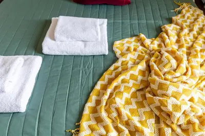 a bed with two towels and a blanket on it at Pass the Keys Spacious and Modern Flat with own Car Park in Cambridge