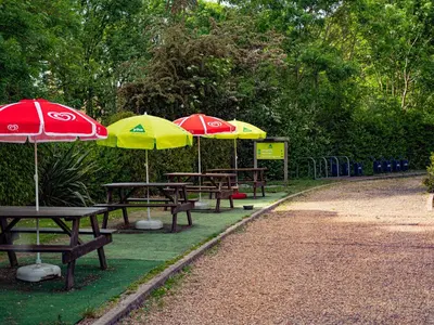 a group of picnic tables with umbrellas in a park at YHA London Lee Valley in Cheshunt