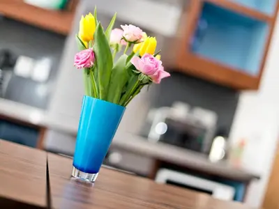 a blue vase filled with flowers on a table at YHA Cambridge in Cambridge