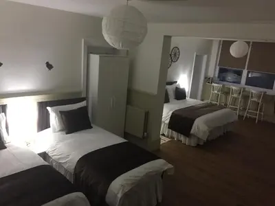 a hotel room with two beds and a mirror at Good Intent Rooms in Waltham Abbey
