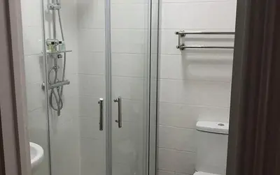 a bathroom with a shower with a glass door at Good Intent Rooms in Waltham Abbey