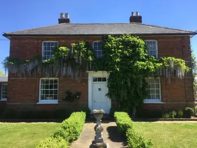 a red brick house with a white door at Waldegrave farm in Hartest