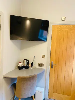 a room with a counter with a television on the wall at The Suffolk Hotel in Haverhill