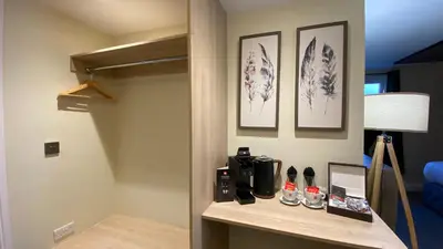 a room with a stairway with a coffee maker on a shelf at The Suffolk Hotel in Haverhill