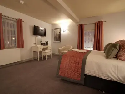 a hotel room with a bed and a desk at The Suffolk Hotel in Haverhill