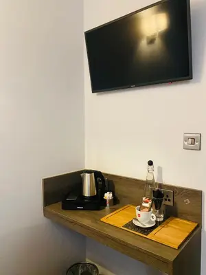 a wooden shelf with a coffee maker and a coffee pot on it at The Suffolk Hotel in Haverhill
