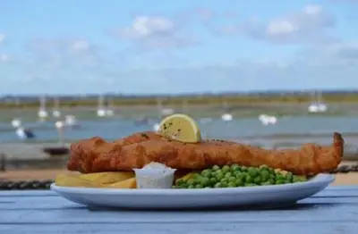a plate of food with fish sticks and peas at The retreat in West Mersea