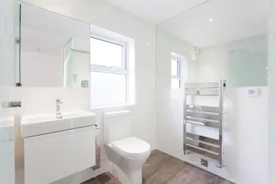 a white bathroom with a toilet and a sink at The Orlando in Cambridge