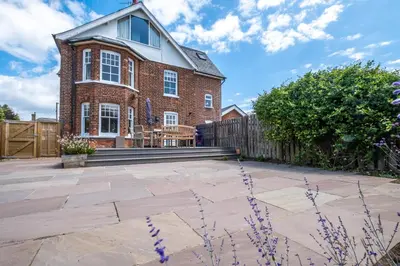 a brick house with a fence and a patio at Lower Saltings in Aldeburgh