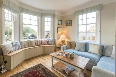 a living room with a couch and a table at Lower Saltings in Aldeburgh