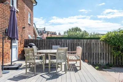 a patio with a table and chairs and an umbrella at Lower Saltings in Aldeburgh