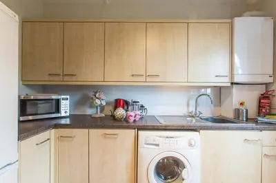 a kitchen with a washing machine and a microwave at Lower Saltings in Aldeburgh
