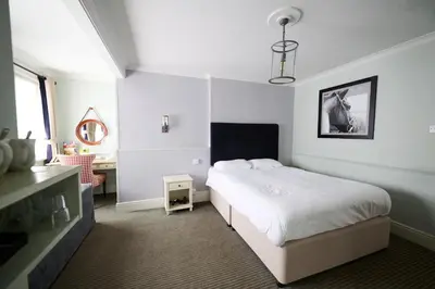 a bedroom with a bed and a desk in it at White Hart, Newmarket by Marston's Inns in Newmarket