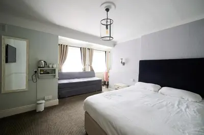 a bedroom with a bed and a couch in it at White Hart, Newmarket by Marston's Inns in Newmarket