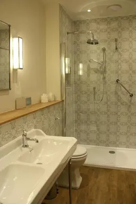 a bathroom with a sink and a toilet and a shower at The Bell Hotel, Saxmundham in Saxmundham