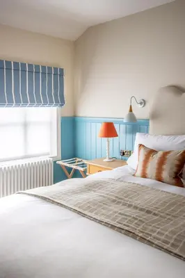 a bedroom with a white bed with a window at The Bell Hotel, Saxmundham in Saxmundham