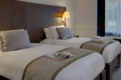 two beds in a hotel room with a book on the bed at Best Western Ipswich Hotel in Ipswich