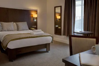 a hotel room with a bed and a table at Best Western Ipswich Hotel in Ipswich