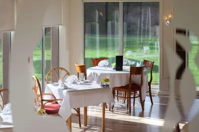 a dining room with a white table and chairs at Best Western Ipswich Hotel in Ipswich