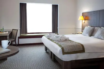 a hotel room with a bed and a table and a window at Best Western Ipswich Hotel in Ipswich
