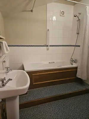 a bathroom with a tub and a sink and a shower at The Swan Inn in Hilborough