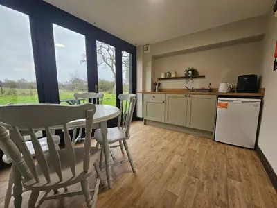 a kitchen and dining room with a table and chairs at The Swan Inn in Hilborough