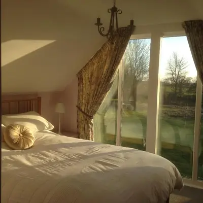 a bedroom with a bed and a large window at Squirrel in Southwold