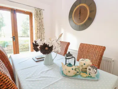 a table with a plate with a tea set on it at The Haybarn in West Bradenham