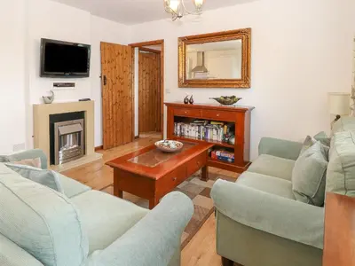 a living room with two couches and a fireplace at The Haybarn in West Bradenham