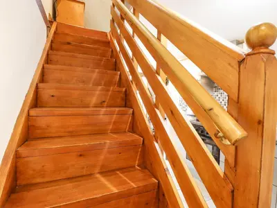 a wooden staircase with wooden railings in a house at The Studio, Horseshoe Cottage in Fulbourn