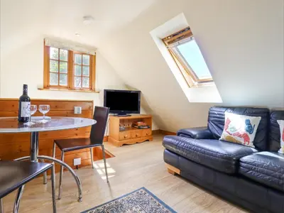 a living room with a couch and a table at The Studio, Horseshoe Cottage in Fulbourn