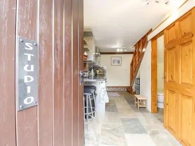a kitchen with a wooden door and a counter top at The Studio, Horseshoe Cottage in Fulbourn