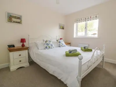 a bedroom with a white bed and a window at Sandlings in Hollesley