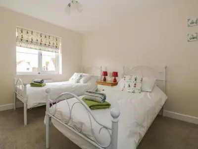 two twin beds in a room with a window at Sandlings in Hollesley
