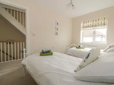 two twin beds in a room with a staircase at Sandlings in Hollesley