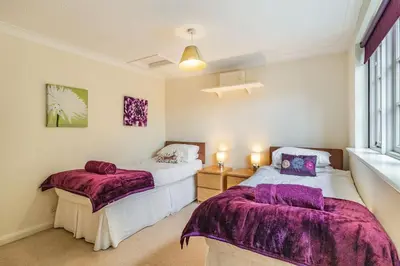 a bedroom with two beds and a window at Ducksfoot Barn in Pulham Saint Mary Magdalene