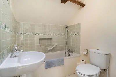 a bathroom with a sink and a toilet and a tub at Ducksfoot Barn in Pulham Saint Mary Magdalene