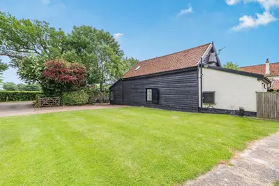 a black and white house with a yard at Ducksfoot Barn in Pulham Saint Mary Magdalene