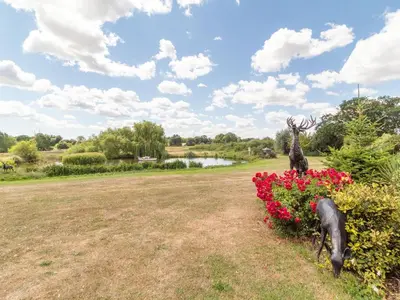 a statue of a deer standing next to flowers at Horseshoe in Little Glenham