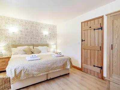 a bedroom with a bed with two towels on it at Horseshoe in Little Glenham