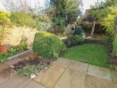 a garden with bushes and a brick wall at 28 Oxborough in Oxborough