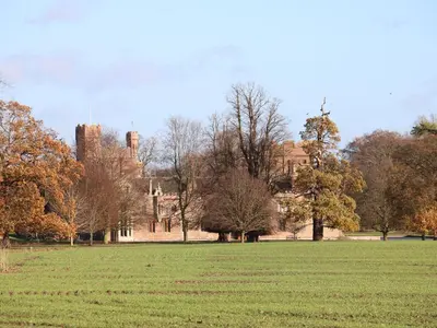 a large grass field with a castle in the background at 28 Oxborough in Oxborough