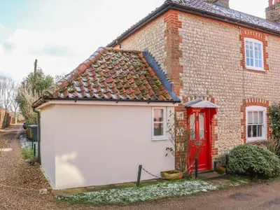 a white garage in front of a brick house with a red door at 28 Oxborough in Oxborough