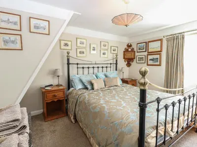 a bedroom with a bed and a staircase at Peggotty's in Kelsale