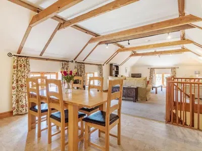 a dining room with a wooden table and chairs at Punch Cottage in Little Glenham