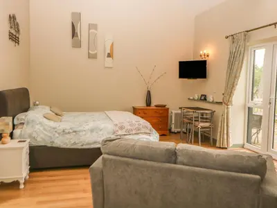 a living room with a bed and a couch at Tawny Owl Barn in Shipdham
